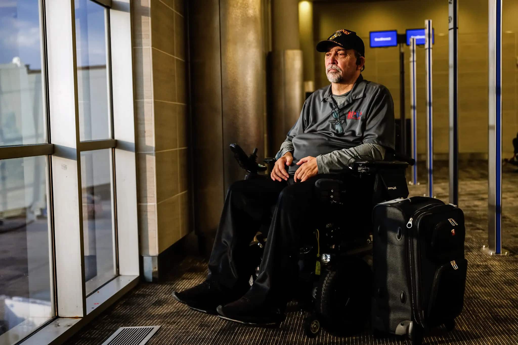 Image of man in wheelchair looking out of airport window