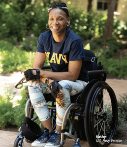 Kathy, U.S. Navy Veteran, poses in her wheelchair in a garden.