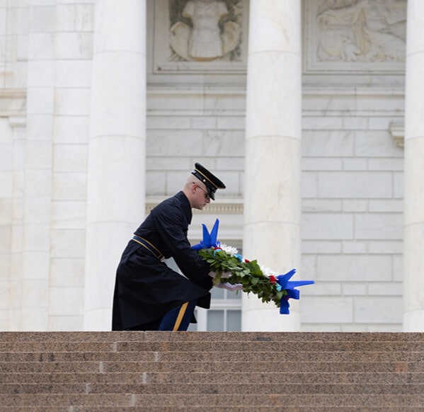 Celebrate Veterans by starting a fundraiser in their honor. Celebrate Veterans by starting a fundraiser in their honor. An image of a military member kneeling to place an arrangement of flowers at a memorial site