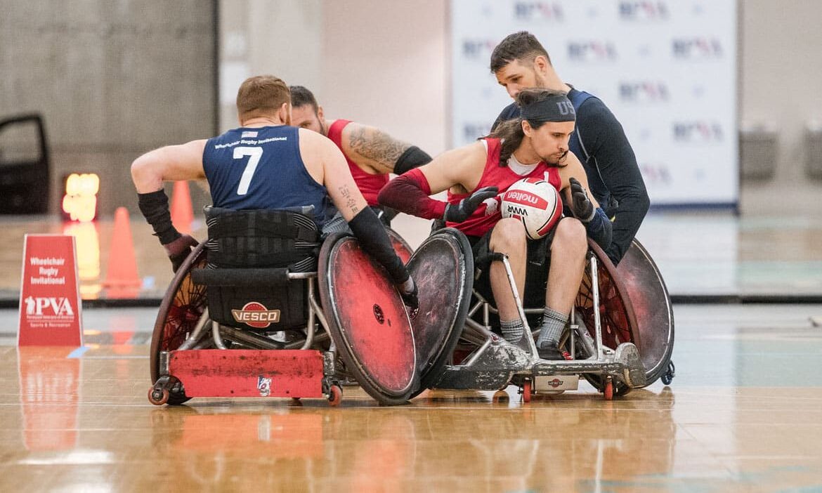  A group of men in wheelchairs playing basketball