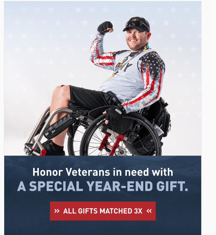 A smiling person in a wheelchair flexes their arm. They are wearing a cap, sunglasses, and an American flag-themed outfit. The text reads: "Honor Veterans in need with a special year-end gift. All gifts matched 3x.