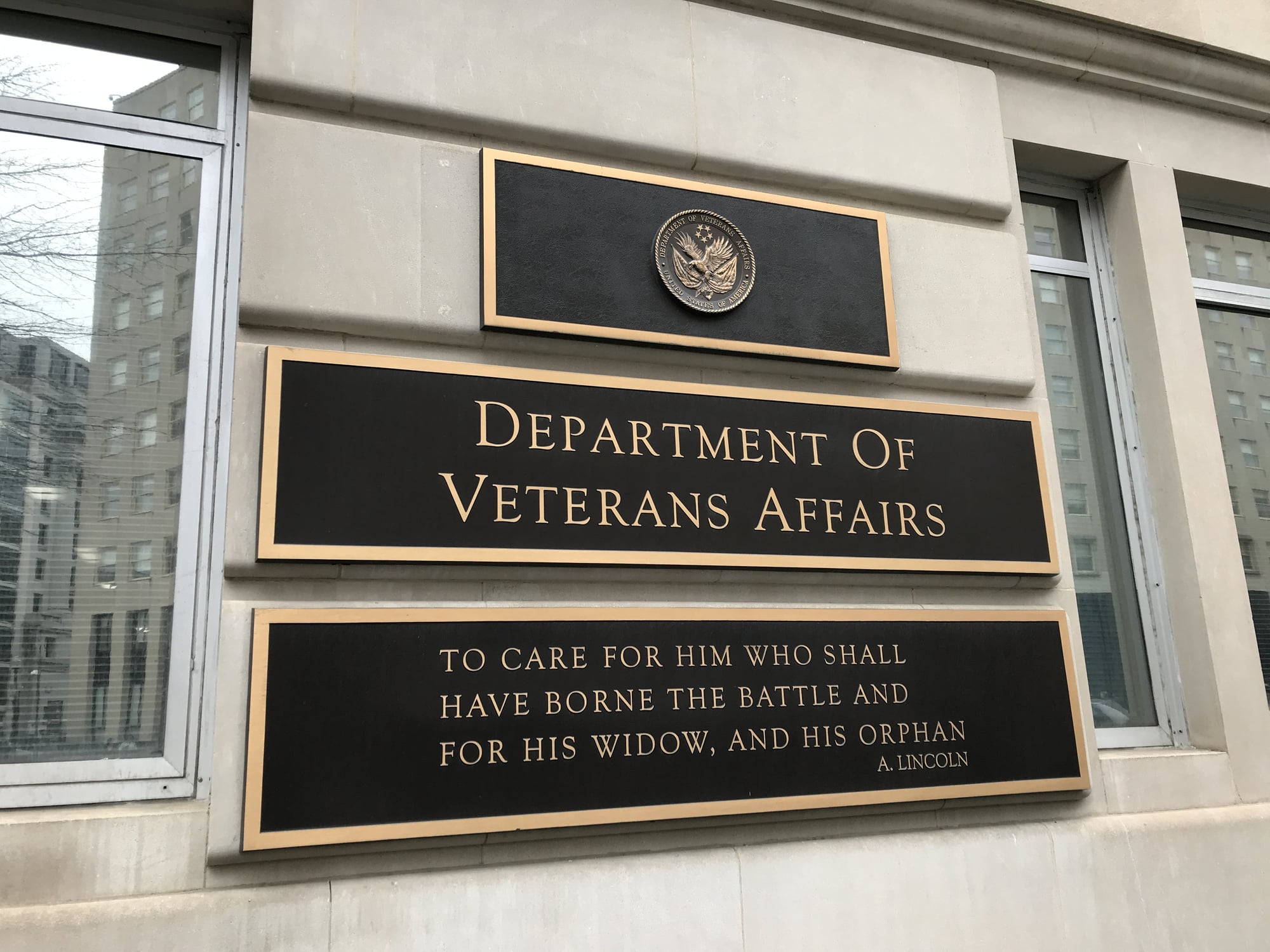 The Department of Veterans Affairs building sign displays a quote by Abraham Lincoln: "To care for him who shall have borne the battle and for his widow, and his orphan.